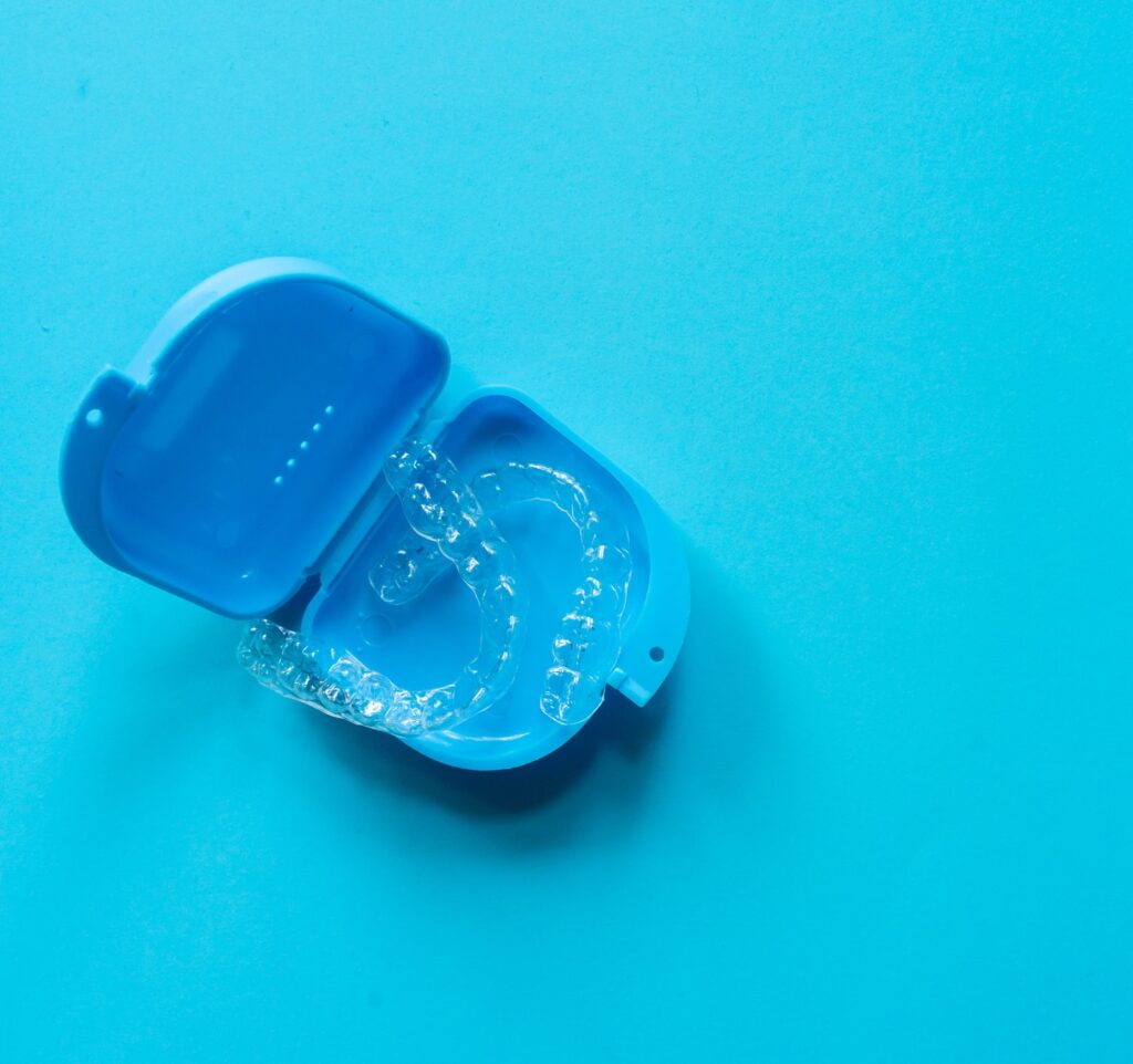 Invisalign clear aligners in a blue container on a blue background