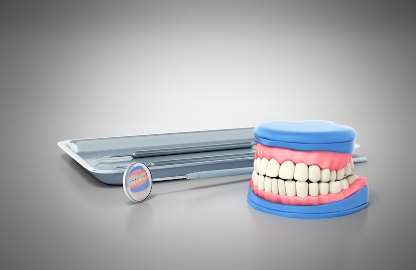 Dental tools on a tray and a model of teeth