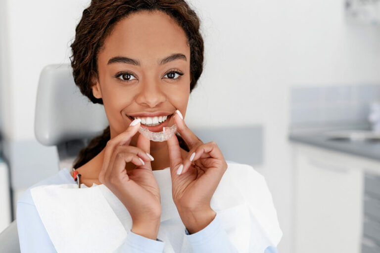 smiling woman holding invisalign