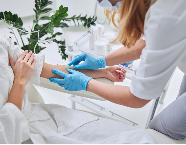 a person putting in an IV in a patients left arm
